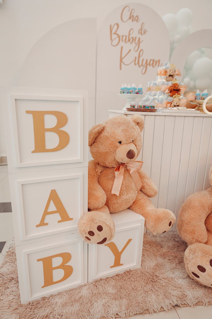 Charming baby shower decor featuring a large teddy bear and alphabet blocks spelling BABY.